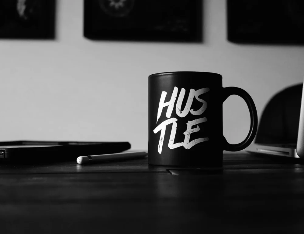 Mug on a desk with hustle written on it.