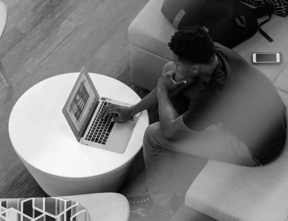 Young man working on a laptop in a relaxed environment.